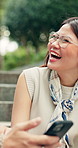 Couple, laugh and relax in park with phone, meme and funny conversation bonding together on weekend. Happy, Japanese people dating and talk outdoor with tech, social media joke and chill in Tokyo.