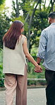 Love, walking and couple in park with holding hands, romantic moment and bonding together on weekend trip. Bokeh, back or people with stroll, partner connection or outdoor date in caring relationship