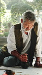 Old man, healer and bowl with herbs for ritual, scripture and herbal medicine for holistic healing. Senior person, mixing and recipe at house with plants, aromatherapy paste and indigenous remedy
