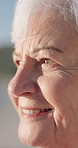 Thinking, calm and senior woman by beach on holiday with nostalgia, remember or memory of travel. Smile, mindfulness and elderly person in retirement by ocean with reflection on seaside vacation. 