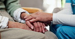 Caregiver, comfort and holding hands with senior person for empathy, compassion and support on sofa. Nursing home, gesture and nurse with elderly patient for sympathy, wellness and care for bonding