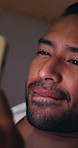 Reading, message and man with phone in bed, biting lip or communication on social media at night. Evening, chat and happy person with mobile app, networking and online dating with tech in house