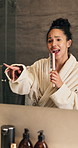 Singing, bathroom and woman with hairbrush in mirror for wellness, grooming or fun for morning routine. Dance, reflection and happy person in home for karaoke, song or energy for self care and health