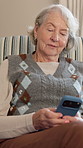 Phone, smile and senior woman in home with texting, chatting or reading blog on retirement. Technology, relax and elderly person with cellphone for online article on app for pension in living room.