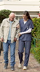Senior, man and walking stick with nurse in outdoor garden for mobility, exercise or support together. Elderly, male person or caregiver helping patient with cane for assisted living or balance