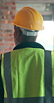 Walking, inspection and back of man in building for construction, remodeling and evaluation. Architecture, contractor and person with assessment for compliance, renovation and planning for property