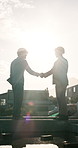 Construction, handshake and people outdoor for meeting, agreement and project approval for building. Contractor, sunshine and men shaking hands for partnership, remodeling and property development
