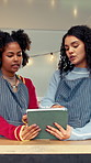 Women, barista and tablet with discussion for menu, social media and food truck cafe teamwork. People, tech and waiter for customer service, partnership or mobile coffee shop review with planning