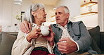 Smile, old couple and relax in home with coffee, love and support for bonding together on sofa. Senior people, rest or beverage on couch with embrace, partner affection and comfortable for retirement