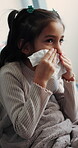 Tissue, sneeze and child blowing nose in bedroom with allergies, flu or viral infection in home. Sick, illness and girl kid with toilet paper for sinusitis, cold or medical virus in bed at house.