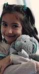 Face, kid and hug in home with teddy bear, comfort or play on weekend break for child development. Happy little girl, embrace stuffed animal or cuddle plush toy in house with love, care and innocence