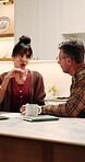 Couple, finance and documents with laptop in kitchen for mortgage payments, bills or investment. Mature man, woman and conversation with paperwork for financial planning or invoices with tech in home