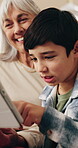 Smile, grandparent and child at house with tablet, browsing and download ebook for education. Senior woman, rest and kid on sofa with digital, watching video and educational games for online learning