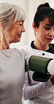 Caregiver, checkup and old woman in retirement home with blood pressure machine, healthcare and help. Senior person, medical worker and equipment for hypertension test, advice and happy with results.