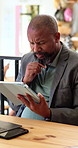 Man, thinking and remote work in cafe with tablet, planning or problem solving for digital marketing. Serious, mature black person or freelancer in restaurant with tech, brainstorming and ad campaign