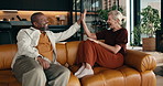 Smile, interracial couple and relax in home with high five, excitement and bonding on anniversary. Happy, mature people and laughing in lounge for celebration, discussion and relationship milestone