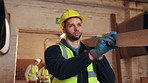 Carpenter, walk and man with plank in workshop, manufacturing and material for furniture production. Warehouse, artisan and person with timber, serious and lumber for woodworking project and flare