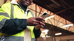 Man, hands and typing in warehouse with phone, check email notification or text message for logistics. Person, browse and worker in workplace with tech, supply chain website or social media on break.