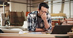 Headache, man and carpenter in workshop with laptop for order cancellation, mistake or negative review. Upset, computer and woodworker with email for error feedback on timber manufacturing project.