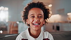 Face, relax and funny kid in home for child development, growth and weekend with happiness. Portrait, smile and adorable African boy in living room to chill, laughing and positive attitude on sofa