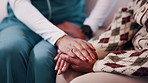 Holding hands, checkup and nurse with woman on sofa in home with empathy for medical diagnosis. Help, volunteer and caregiver with mature patient in living room for support on healthcare recovery.