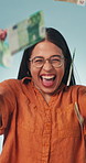 Excited woman, face and money rain in studio for win, financial freedom and success on blue background. Cash, funny person or lottery celebration with reward, rich or fist pump for wealth achievement