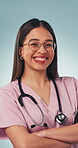 Wellness, face and nurse with arms crossed, clinical service and pride in medical career. Portrait, glasses or happy woman with confidence, healthcare practitioner or about us on studio background.