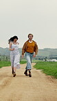 Holiday, running or couple in countryside with fun, bonding together or happy moment on trip. Laugh, space or people with holding hands, romantic relationship or playful connection on outdoor getaway