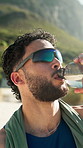 Runner, man and drinking water outdoor with break, sunglasses and training recovery for wellness. Fitness, person and exercise rest in nature with beverage, electrolytes and cool down in summer.
