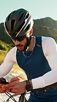 Fitness, man and phone in nature with bicycle, sunglasses and social media update for cardio training. Active, male person and typing outdoor with tech, safety helmet or cycling break for reflection.