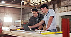 People, carpenter and reading in workshop with laptop, research and review design for production. Team, meeting or pc in factory for carpentry, online blueprint and policy for manufacturing furniture