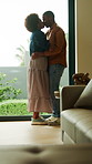 Happy, couple and kiss in house with dance, embrace and connection for bonding together on weekend. Black people, dating and hug in living room with love, romantic relationship and rhythm to music.