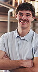 Arms crossed, carpentry and face of happy man in warehouse for manufacturing or production. Confident, industry and smile of person in woodworking warehouse for management of furniture business