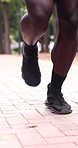 Legs, man and running at park for fitness, exercise and cardio training for morning routine. Below, male person and jogging in nature for sports, endurance workout and physical activity for wellness