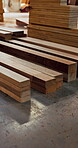 Woodworking, workshop and lumber stack on floor, manufacturing and material for furniture production. Carpentry, process and custom timber for architectural project, restoration and craftsmanship