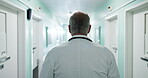 Man, doctor or walking in hospital for healthcare, schedule or appointment punctuality for care. Back, hallway or mature specialist in clinic with medical professional, consultation or service minded