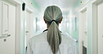 Woman, doctor and walking in hospital for healthcare, schedule and appointment punctuality for care. Back, hallway and mature specialist in clinic with medical professional, consult or service minded