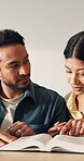 Bible, couple and reading in home for religious study, faith and worship with knowledge. Book, gospel and people with pointing at scripture for Christianity, Jesus and spiritual guidance for growth