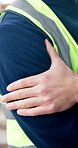 Construction, shoulder pain or hands outdoor with massage, injury or labor issue on building site. Accident, man or engineer with joint sprain, muscle strain or arm tension in development project.