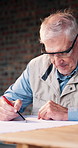 Construction, site and man with writing for blueprint correction, drawing update and renovation. Goggles, mature architect and notes on floor plan for building compliance, layout change and schematic