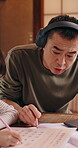 Daughter, education and video call with Asian man in headphones for online class or virtual school. Digital course, laptop and writing with dad speaking to girl child in apartment for homeschooling