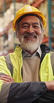 Face, confident and man in warehouse as logistics manager, distribution worker and laughing. Arms crossed, happy and mature Asian person in shipping industry, quality control or safety with helmet