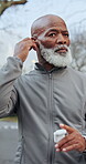 Earbuds, fitness and walking with black man outdoor for start of cardio routine or training. Exercise, getting ready and music with mature runner in park for commitment to health activity or wellness
