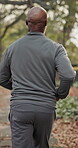 Back, exercise and running with black man outdoor on street for cardio training or workout. Commitment, fitness and wellness with runner in neighborhood for morning activity or physical health