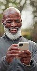 Phone, earphones and black man in park for texting, chatting or social media with fitness advice. Technology, laugh and mature person with cellphone for sports blog or article on app for exercise