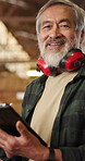 Earmuffs, face and tablet with happy man in carpentry factory for management of manufacturing plant. App, industry and production with mature carpenter in woodwork warehouse for professional joinery