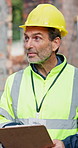 Construction, clipboard or man with inspection, site check or quality control for building project. Industrial, ppe or mature engineer with checklist, progress track or evaluation in risk assessment.
