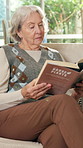 Reading, relax and senior woman on sofa in home living room for hobby or house plants research. Book, information and retirement with old person in apartment for gardening knowledge or study