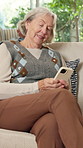 Laughing, phone and relax with old woman on sofa in home living room for social media browsing. App, retirement and text message with senior person in apartment for break or mobile communication