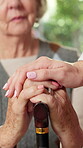 Cane, comfort and hands of old person with nurse in retirement home for assisted living support. Care, conversation and walking stick of senior patient in apartment with caregiver for healthcare